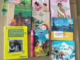 several children ' s books are lined up on a cardboard box