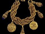 a gold bracelet with charms and charms on a black background
