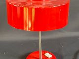 une lampe de table rouge posée sur une table noire