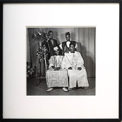 black and white photograph of a group of people sitting on a couch