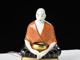 a figurine of a person sitting in a meditation position