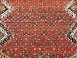 an oriental rug with a red background and a gold border