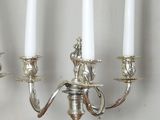 a silver candelab with four white candles on it