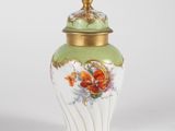 a vase with a lid that has flowers on it