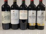 six bottles of red wine lined up on a counter top