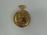 a small gold pocket watch on a white surface