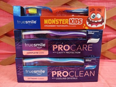 trois boîtes de brosses à dents sont empilées les unes sur les autres