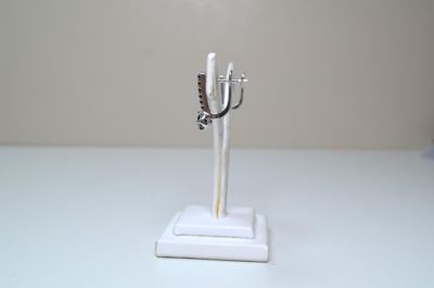 une statue en argent représentant une femme tenant un couteau, posée sur un socle