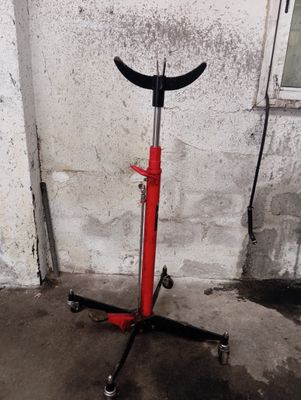 un pied de table rouge et noir muni d'une poignée noire et d'une poignée noire