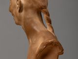 sculpture of a woman ' s head with braids on a wooden table