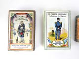 three matchboxes of different colors and designs on a white surface