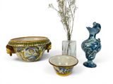 three vases, a bowl, and a vase with flowers in them