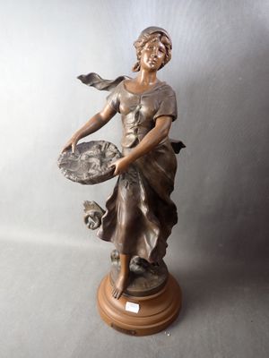bronze statue of a woman holding a tray of food on a wooden base