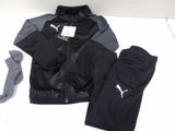 a black and gray jacket and pants on a bed