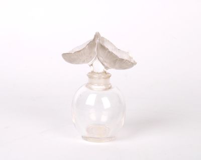 LALIQUE. Flacon en cristal. De forme boule, le bouchon orné …