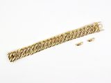 gros plan d'un bracelet en or sur une surface blanche