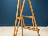 an image of a wooden ladder stands against a blue wall