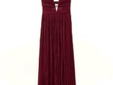 a red dress hanging on a hanger on a white wall