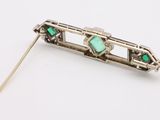 an image of a silver and green broochle pin on a white background