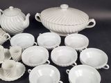 a lot of white dishes and cups on the table
