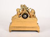 a gold clock with a black marble ball on top of it