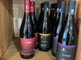 plusieurs bouteilles de vin sur une étagère dans un magasin
