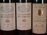 three bottles of red wine are lined up on a table