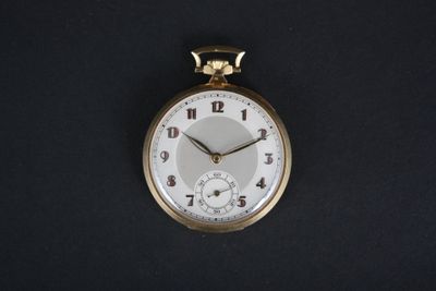 une montre de poche en or avec un cadran blanc sur fond noir