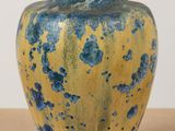 a blue and yellow vase sitting on a table