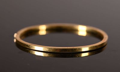 a close up of a gold ring on a black surface