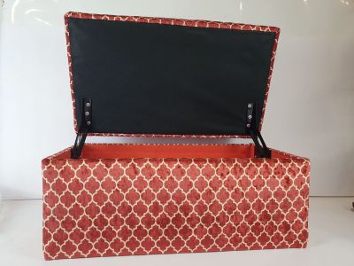 une boîte rouge avec un couvercle noir posée sur une table blanche