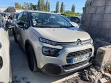 La voiture est garée sur le parking, à côté d'autres voitures.
