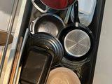 a drawer full of pots and pans in the kitchen
