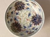 un bol blanc orné de motifs bleus et marron