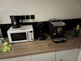 un micro-ondes et une cafetière posés sur le plan de travail de la cuisine