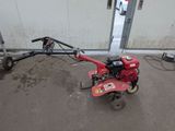 a small red machine that is sitting on the ground