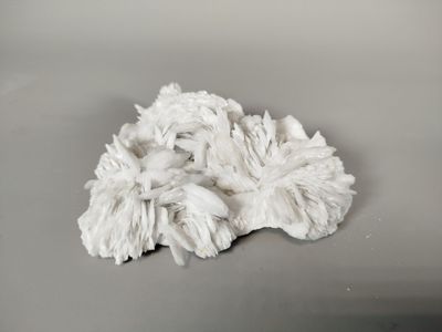 a white mop on a table with a gray background