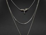 a woman wearing a necklace that has a bird on it