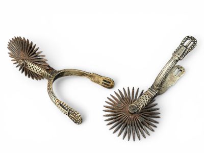 pair of antique silver and gold metal sunbursts on a white background