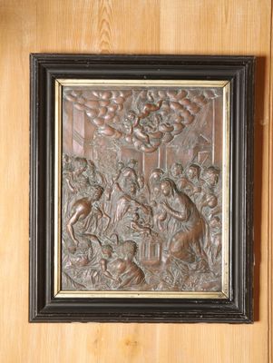une photo d'un relief en métal sur un mur en bois