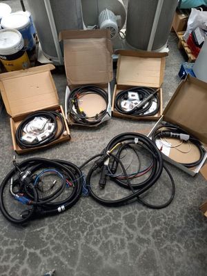 plusieurs cartons remplis de câbles, ainsi que des câbles éparpillés sur le sol