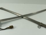 two swords on a white table with a cord