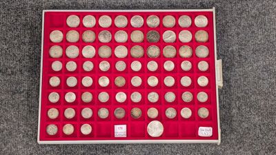 une boîte rouge remplie de nombreuses pierres, posée par terre