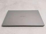 a laptop that is sitting on a bed with a white sheet