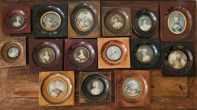 many framed pictures of people on the wall of this room