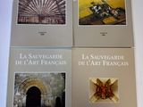 quatre livres posés sur une table blanche, avec une photo d'un bâtiment en arrière-plan