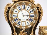 a clock that is sitting next to a cup on a table