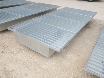 de nombreuses grilles en acier posées au sol à côté d'un camion