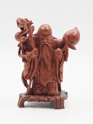 figurine chinoise sculptée représentant un homme tenant un pot et un oiseau