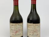 two bottles of red wine sitting next to each other on a white surface